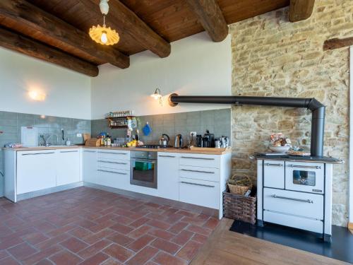 a kitchen with white appliances and a brick wall at Apartment Purin I by Interhome in Murazzano