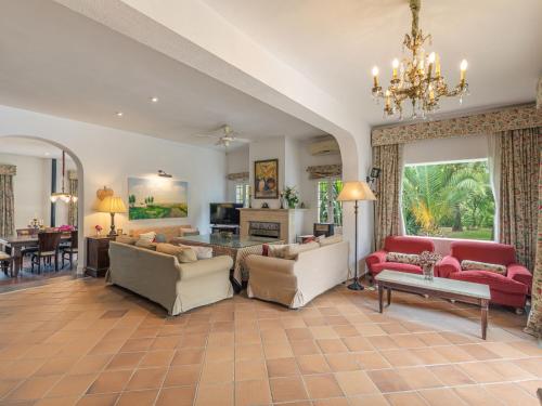 a living room filled with furniture and a chandelier at Villa Las Codornices-1 by Interhome in Sanlúcar la Mayor