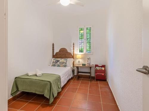 a small bedroom with a bed and a table at Villa Las Codornices-1 by Interhome in Sanlúcar la Mayor