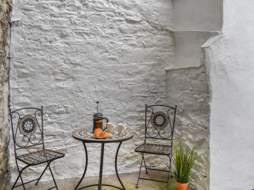 a table with two chairs and a table with food on it at Ty Ni in Bala