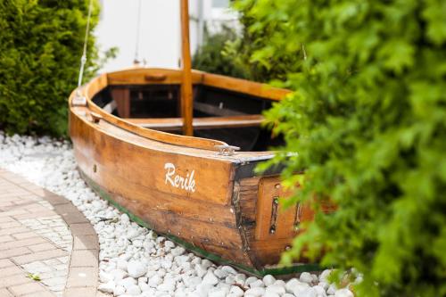 an old wooden boat sitting on some rocks at Appartementhaus Strandnähe in Warnemünde