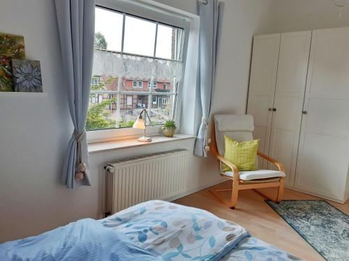 a bedroom with a bed and a chair and a window at Ferienwohnung am Heidesee in Faßberg