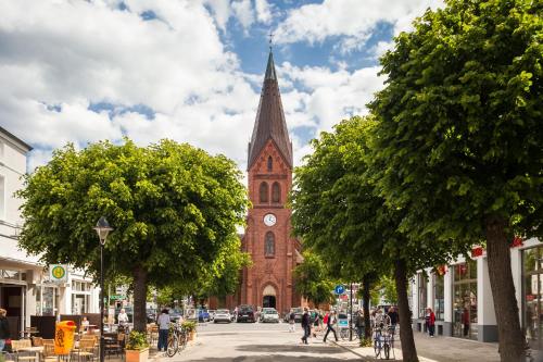 a church with a clock tower on a city street at Appartementhaus Strandnähe in Warnemünde