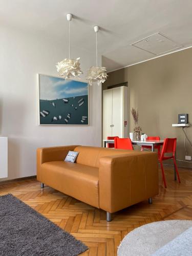 a living room with a brown couch and a table at Elegante Apartmento nel centro storico di Treviso in Treviso