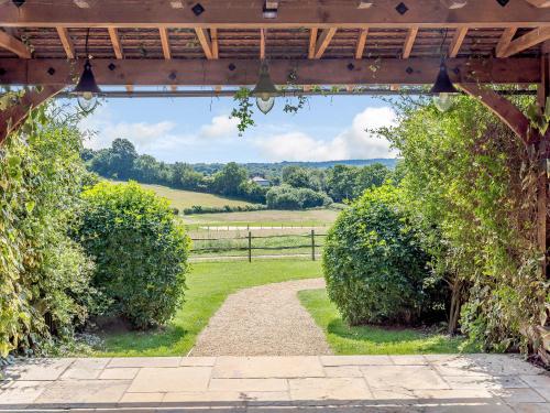 an entrance to a garden with bushes and a fence at Castlemans Stables East in Sedlescombe