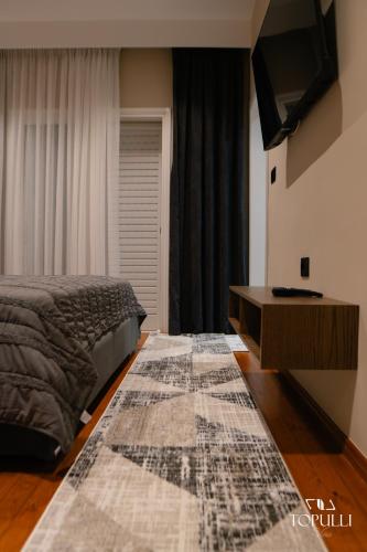 a bedroom with a bed and a rug on the floor at Villa Topulli View in Gjirokastër