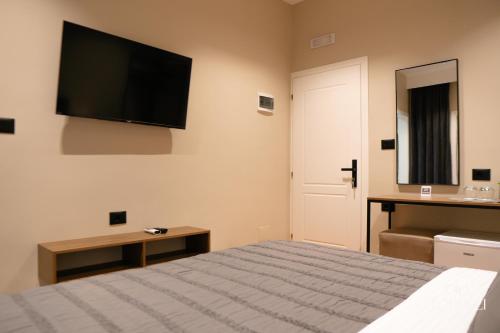 a bedroom with a bed and a flat screen tv at Villa Topulli View in Gjirokastër