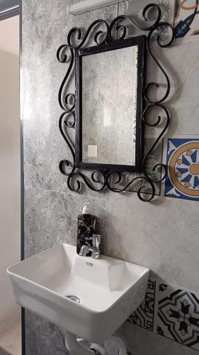 a bathroom with a sink and a mirror on the wall at Mithila Homestay in Thanjāvūr
