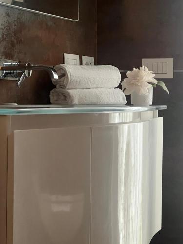 a shelf with towels on it in a bathroom at Comfortable apartment - Monza park with garage in Biassono