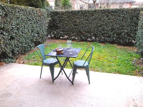 - une table avec deux chaises et une assiette de nourriture dans l'établissement Studio calme dans une belle résidence avec piscine • Parking • WiFi, à Toulouse
