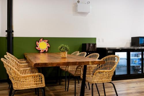 a wooden table with chairs and a green wall at Samesun Vancouver in Vancouver