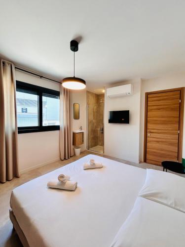 Coliving - Private Shower - Bfast & Terrace Dining في كاجنيس سور مير: غرفة نوم بها سرير أبيض كبير مع مناشف عليه