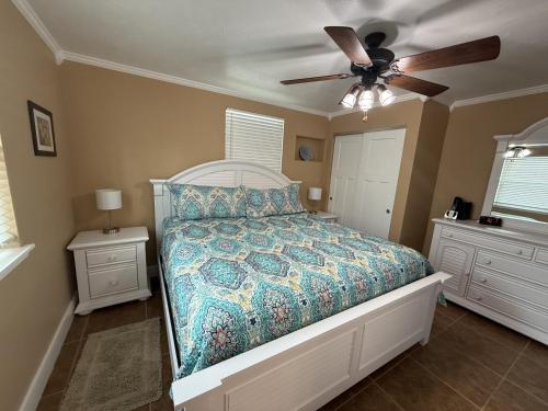 a bedroom with a bed and a ceiling fan at Palm Haven Beach Side Villa in Holmes Beach