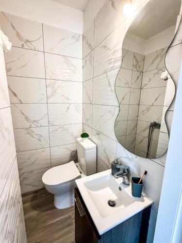 a bathroom with a sink and a toilet and a mirror at Oasis by the Pool in Nea Kallikrateia