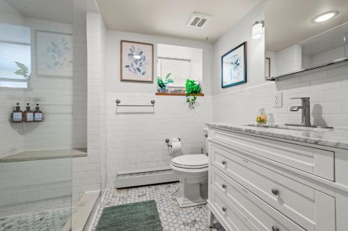 a white bathroom with a toilet and a sink at Jersey City Retreat w Private Backyard Bonfire Near NYC in Jersey City