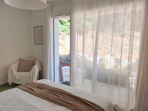 une chambre avec un lit et une porte coulissante en verre dans l'établissement Appartement tout confort à l'Ile-Rousse, à LʼÎle-Rousse