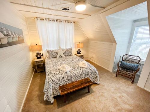 una camera da letto con un letto, una sedia e una finestra di Historic Waterfront, Downtown, Boat Slip Avail a Swansboro