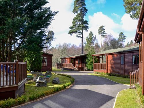 a walkway between two cabins in a resort at Lodge G- Uk33093 in Dinnet