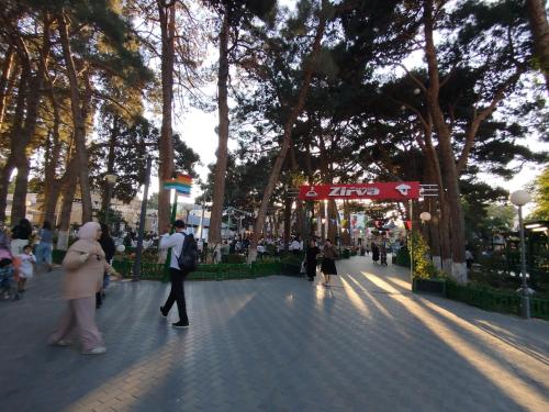 a group of people walking down a street with trees at Baku Lake view apartment in Xirdalan