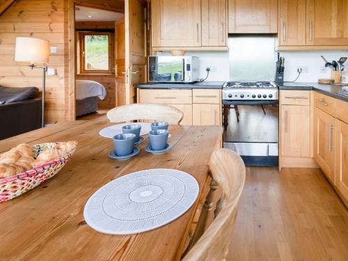 a small kitchen with a wooden table with a table at Tunturi - Cottage in Linlithgow