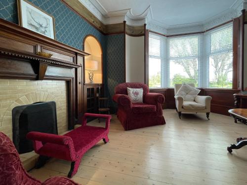 a living room with two chairs and a fireplace at Stanford House in Inverness