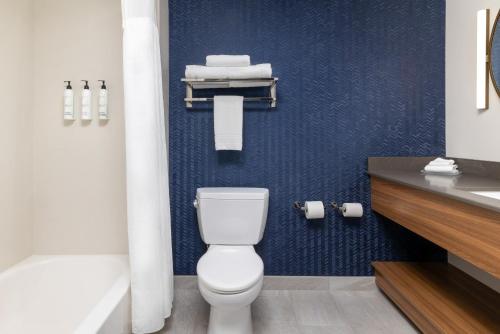 a bathroom with a white toilet and a blue wall at Fairfield by Marriott Inn & Suites Spokane Airport in Spokane
