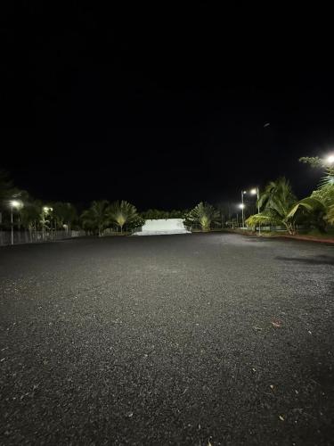 an empty parking lot at night with lights at KP Farms in Alūr