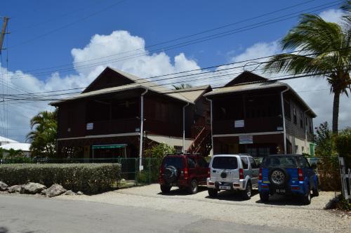 two cars parked in front of a building at White Coconut Studio in Christ Church