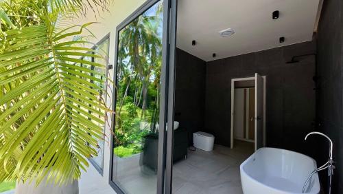 a bathroom with a large window and a bath tub at Beautiful villa with pool in Koh Phangan