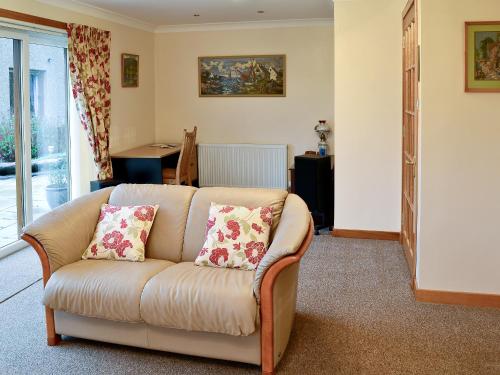 a living room with a couch with two pillows at Eilean Donan in Kirknewton