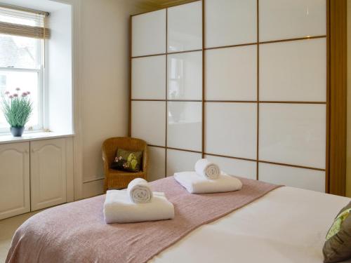 a bedroom with a bed with two towels on it at Buckle House in Gatehouse of Fleet