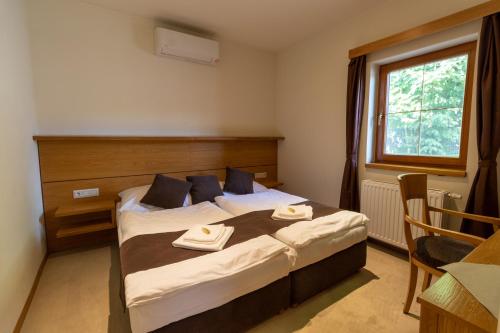 a bedroom with a bed with two towels on it at Hotel resort Lovecká bašta Strakonice in Strakonice