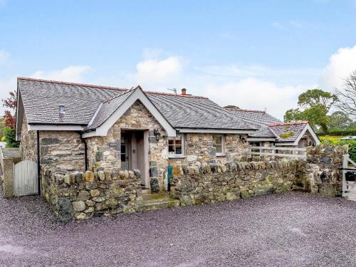 a stone house with a stone wall at Bwthyn - Uk31387 in Caeathro