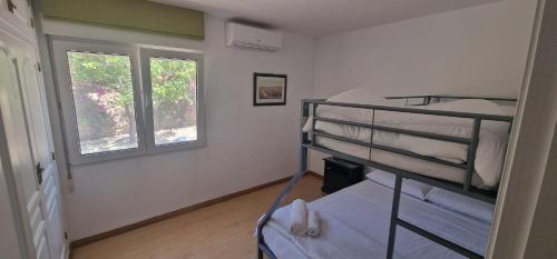 a bedroom with two bunk beds and two windows at Beachfront Villa in Moraira