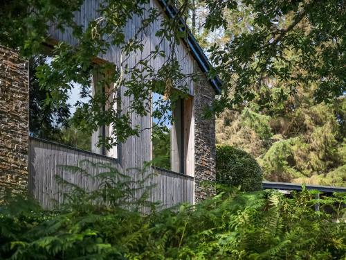 a window on the side of a house with trees at Carsaig in Port of Menteith