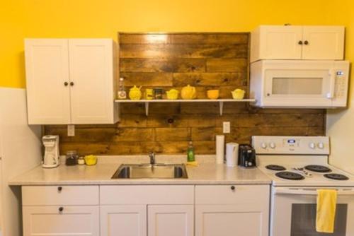 a kitchen with a sink and a stove and microwave at Canalside Restaurant & Inn in Port Colborne