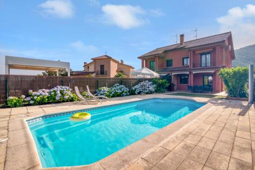 a swimming pool in front of a house at Casa Gredos- Chimenea , Setas , BBQ , Relax in Mombeltrán