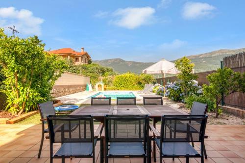 a patio with a table and chairs and a pool at Casa Gredos- Chimenea , Setas , BBQ , Relax in Mombeltrán