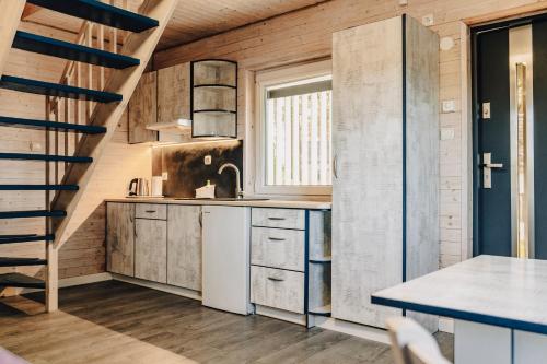 a kitchen with wooden walls and a spiral staircase at Blue Resort Ostrowo in Ostrowo