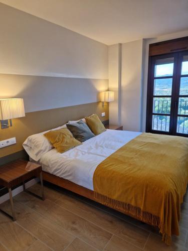 a bedroom with a large bed with a yellow blanket at Casa Albañil in La Puebla de Castro