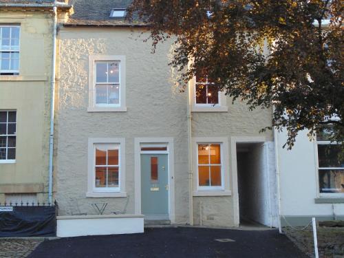 a white house with a blue door and windows at Newburgh C Listed Townhouse in Newburgh