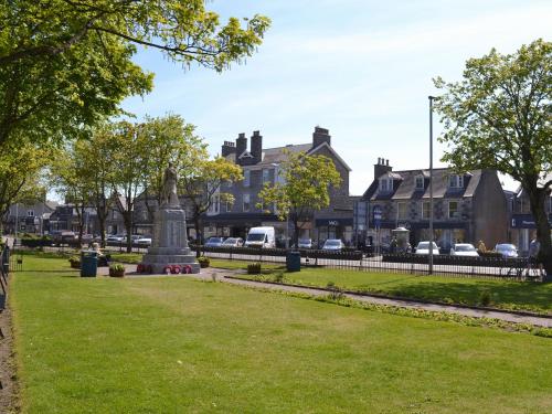 a statue in a park in front of houses at Inver House Apartment in Inverurie