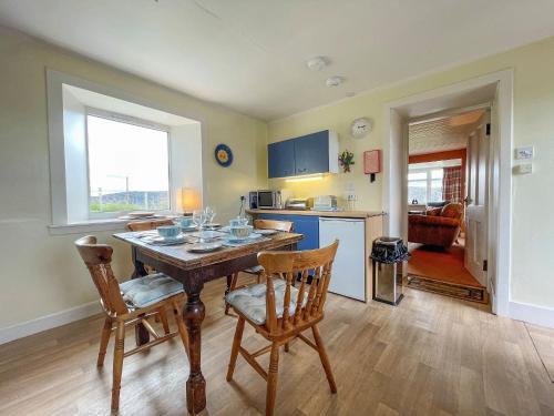 a kitchen and dining room with a table and chairs at Dalcharn in Bettyhill