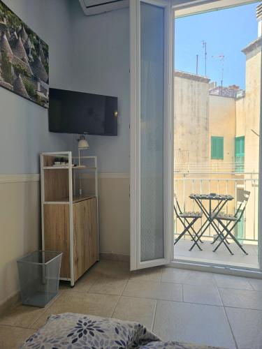 a living room with a view of a table and a balcony at PURA VITA apartments in Monopoli
