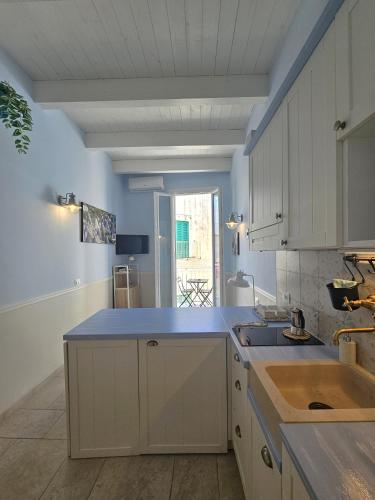 a kitchen with white cabinets and a blue counter top at PURA VITA apartments in Monopoli