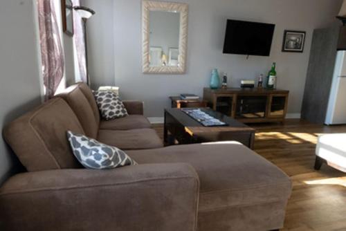 a living room with a couch and a tv at Canalside Restaurant & Inn in Port Colborne