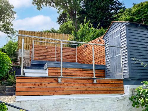 a house with wooden steps and a fence at Driftwood in Aberdyfi