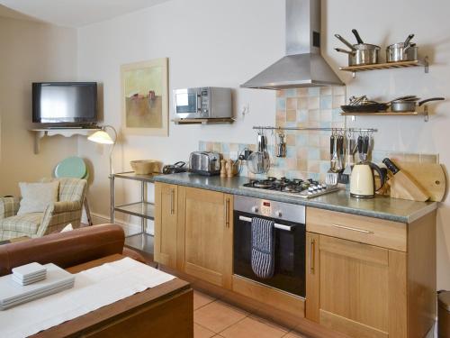 una cocina con encimera y estufa horno superior en Youngers Cottage, en Warkworth