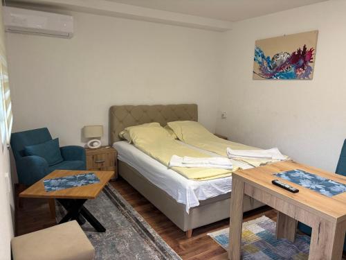a small bedroom with a bed and a table at Apartments Jasmin in Goražde