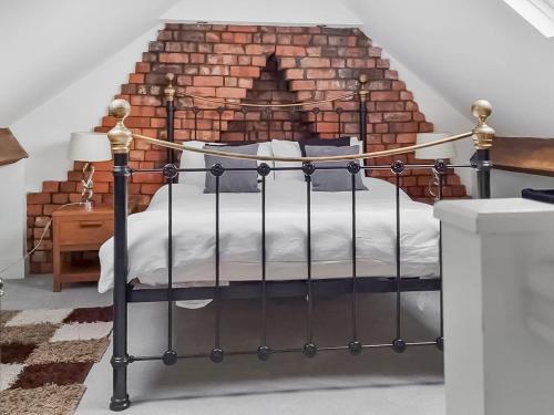 a bedroom with a bed in front of a brick wall at Hill View in Abertillery